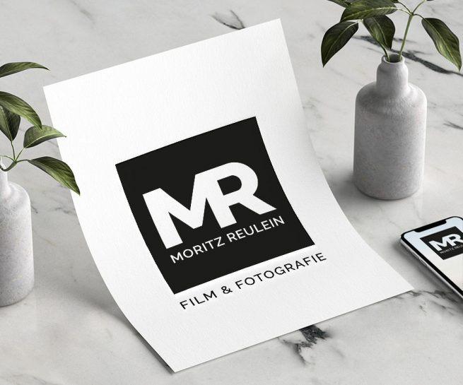 Mockup von einem Blatt und Mobiltelefon mit dem Logo von Moritz Reulein Film und Fotografie Ulm