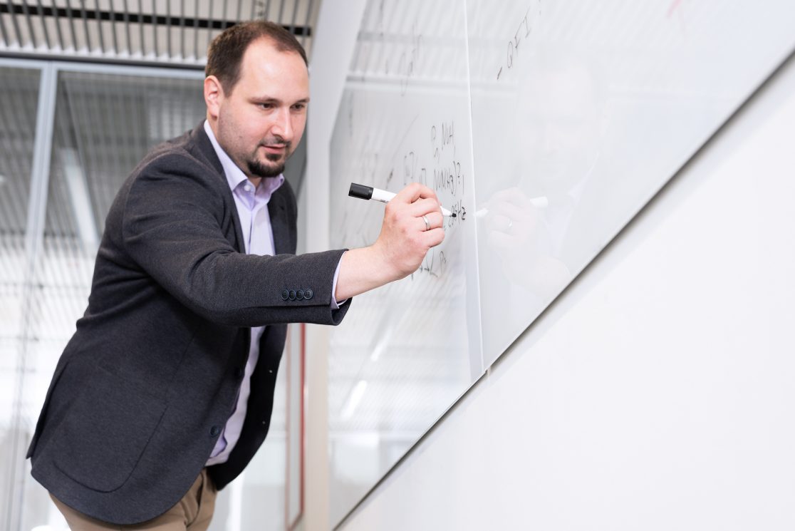 Mitarbeiter schreibt auf Whiteboard