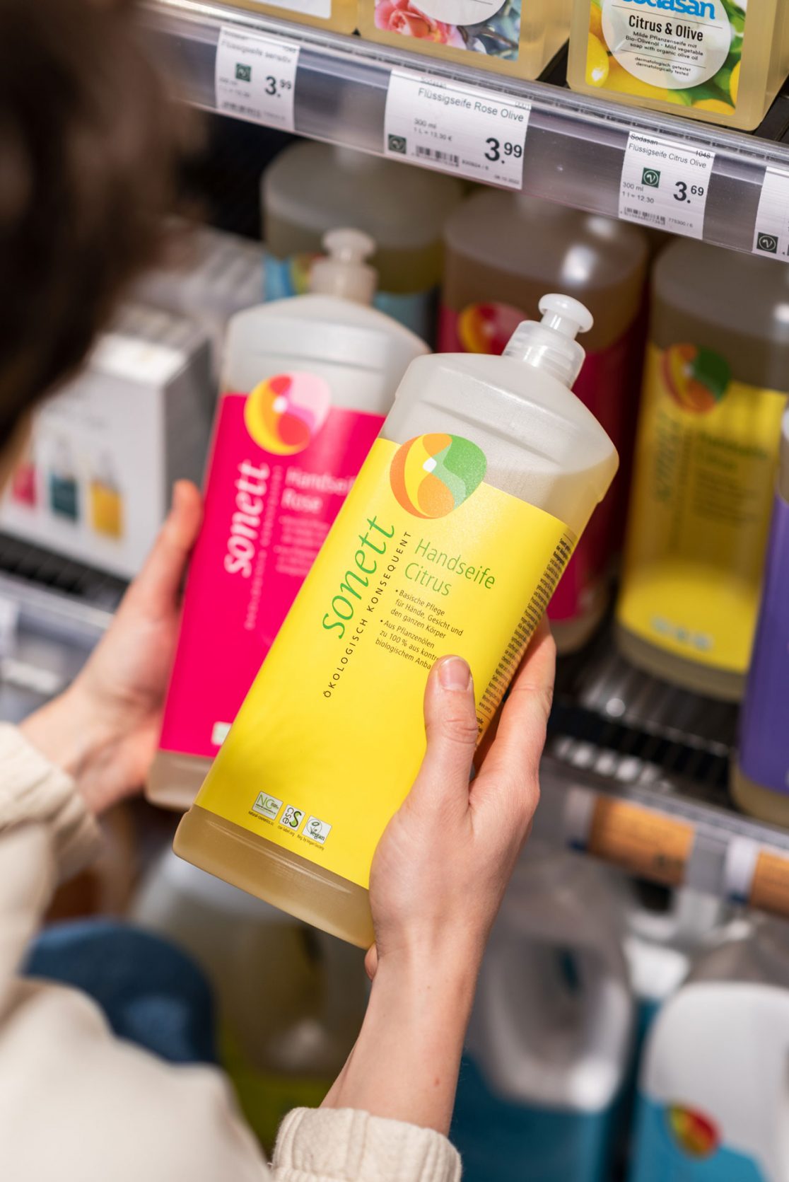 Person hält zwei Handseife Flaschen der Marke Sonett