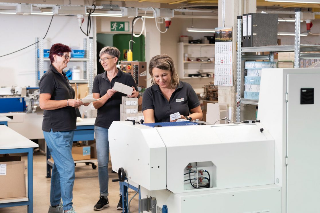 Foto von Mitarbeitern in der Produktion der Firma Glücksband Göppingen im Gespräch